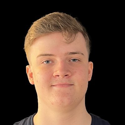Der junge Mann hat blaue Augen und trägt ein dunkles T-Shirt, während er direkt in die Kamera schaut.