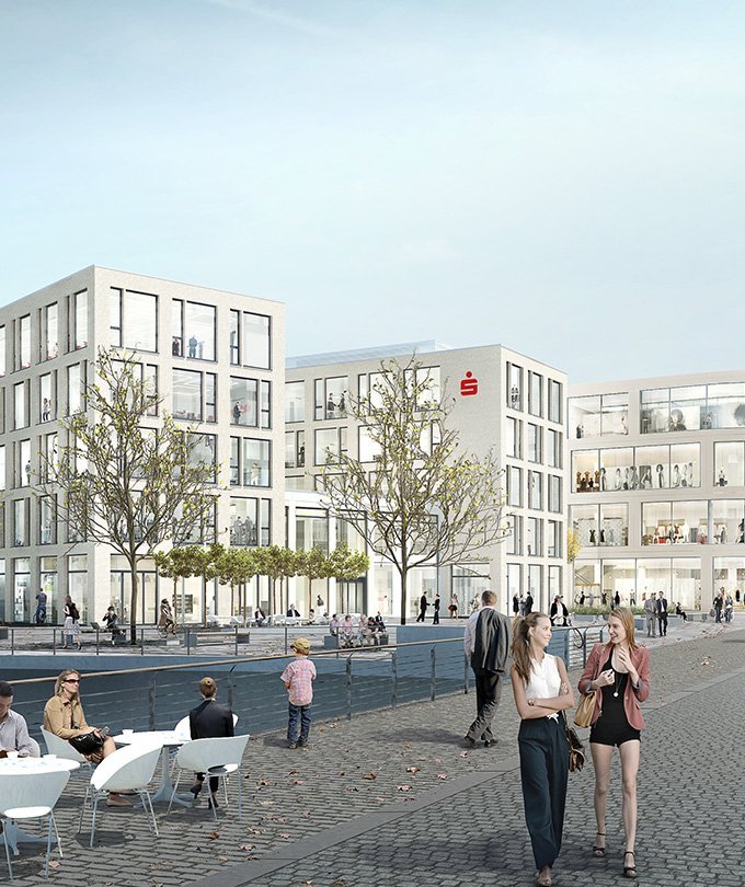 Zwei Frauen unterhalten sich lächelnd auf einem belebten Platz vor modernen Gebäuden mit großen Fenstern.