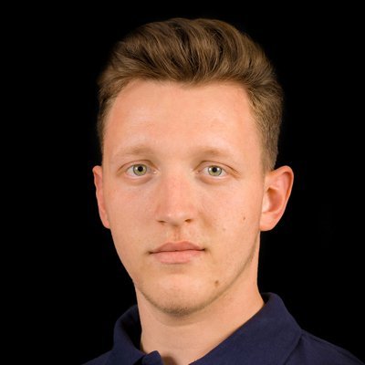 Ein junger Mann mit kurzen, blonden Haaren und einem neutralen Gesichtsausdruck blickt direkt in die Kamera.