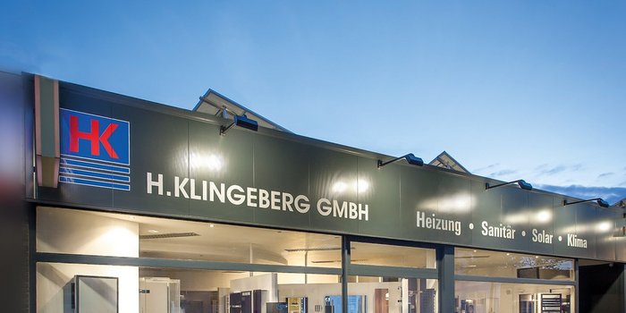 Das moderne Firmengebäude von H. Klingeberg GmbH zeigt eine klare Fassade mit dem Logo und Dienstleistungen wie Heizung und Sanitär.