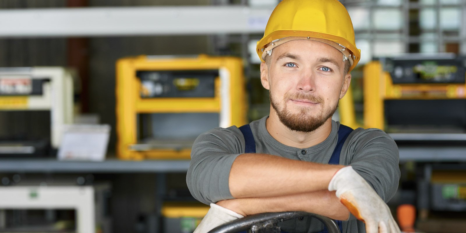 Ein Bauhelfer der einen Bauhelm trägt